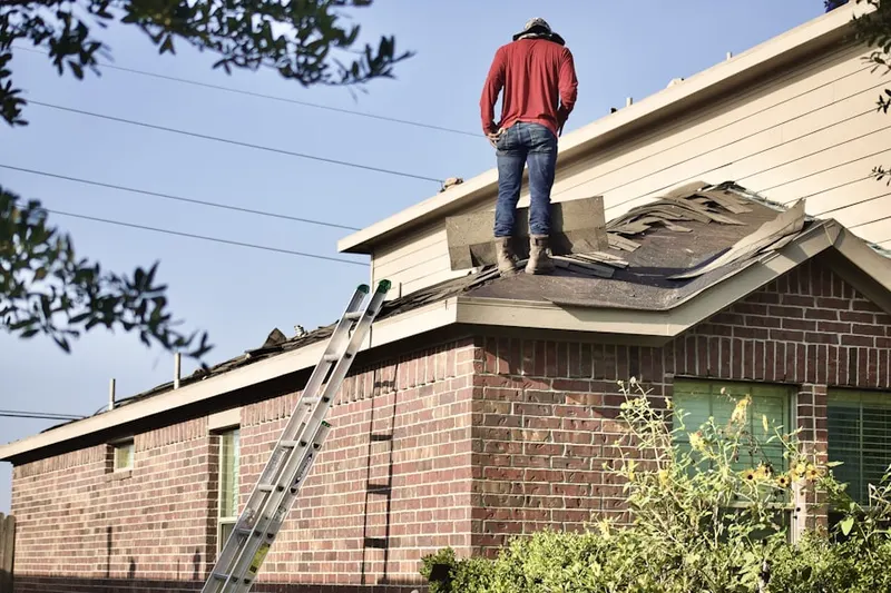 Professional roofer working on a residential roof in Saticoy